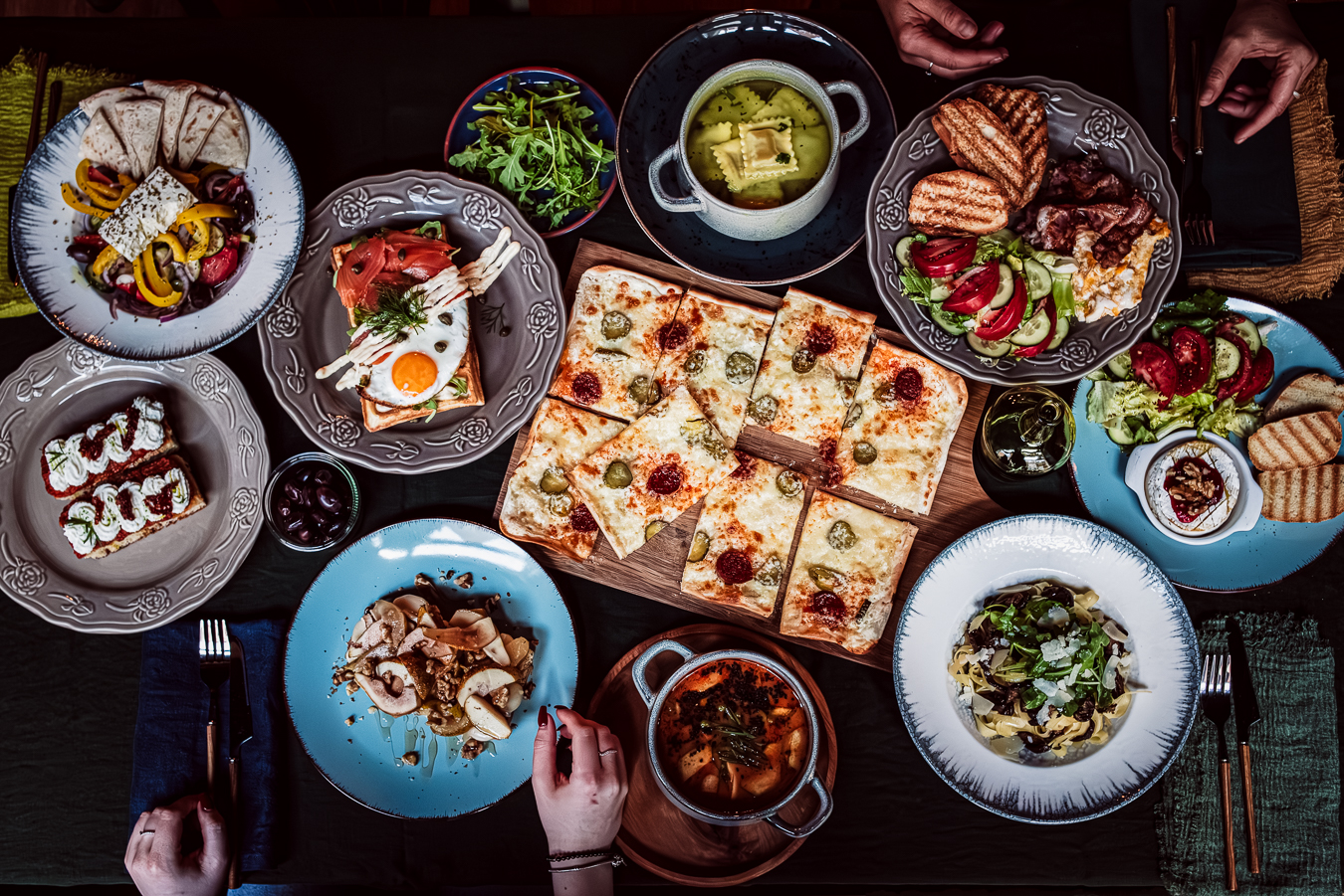Stół pełen dań w Ponad Czasem — pizza, śniadania, sałatki, zupy i wypieki